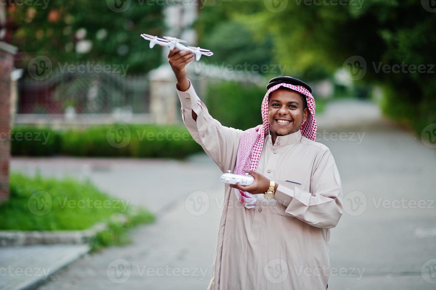 homme d'affaires arabe du moyen-orient posé dans la rue avec un drone ou un quadricoptère à portée de main. photo