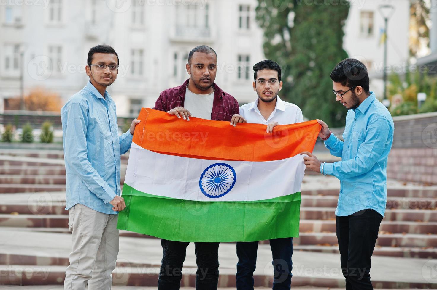 groupe de quatre hommes indiens d'asie du sud avec le drapeau de l'inde. photo