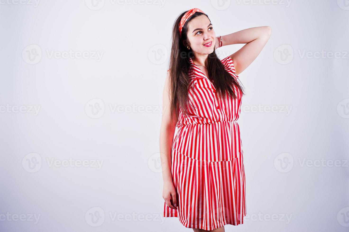 portrait d'une magnifique jeune fille en robe rayée rouge en studio. photo