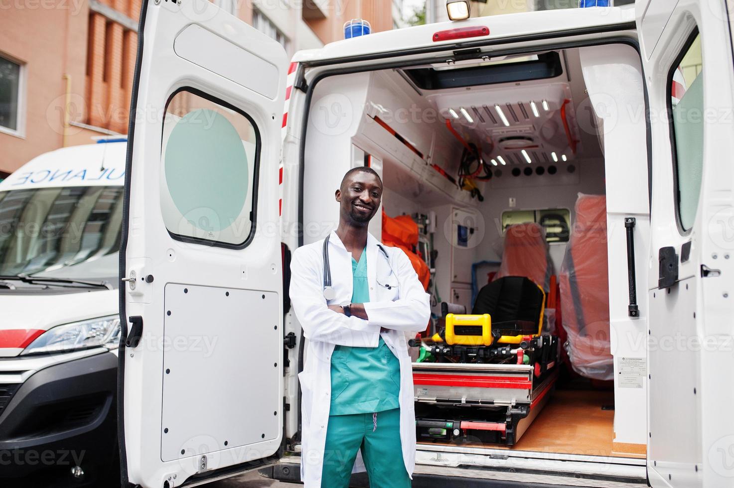 paramédic masculin africain debout devant la voiture d'ambulance. photo