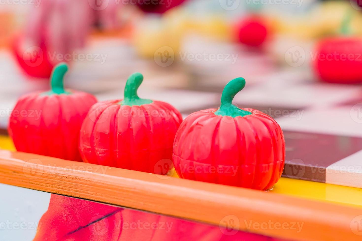 trois citrouilles rouges en plastique d'affilée, vue en perspective, mise au point sélective photo