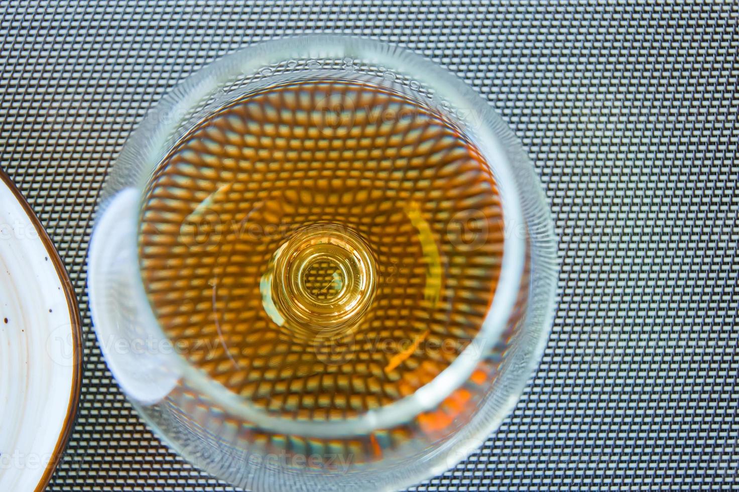 petit verre à vin avec cognac ou brandy sur une table. vue de dessus photo