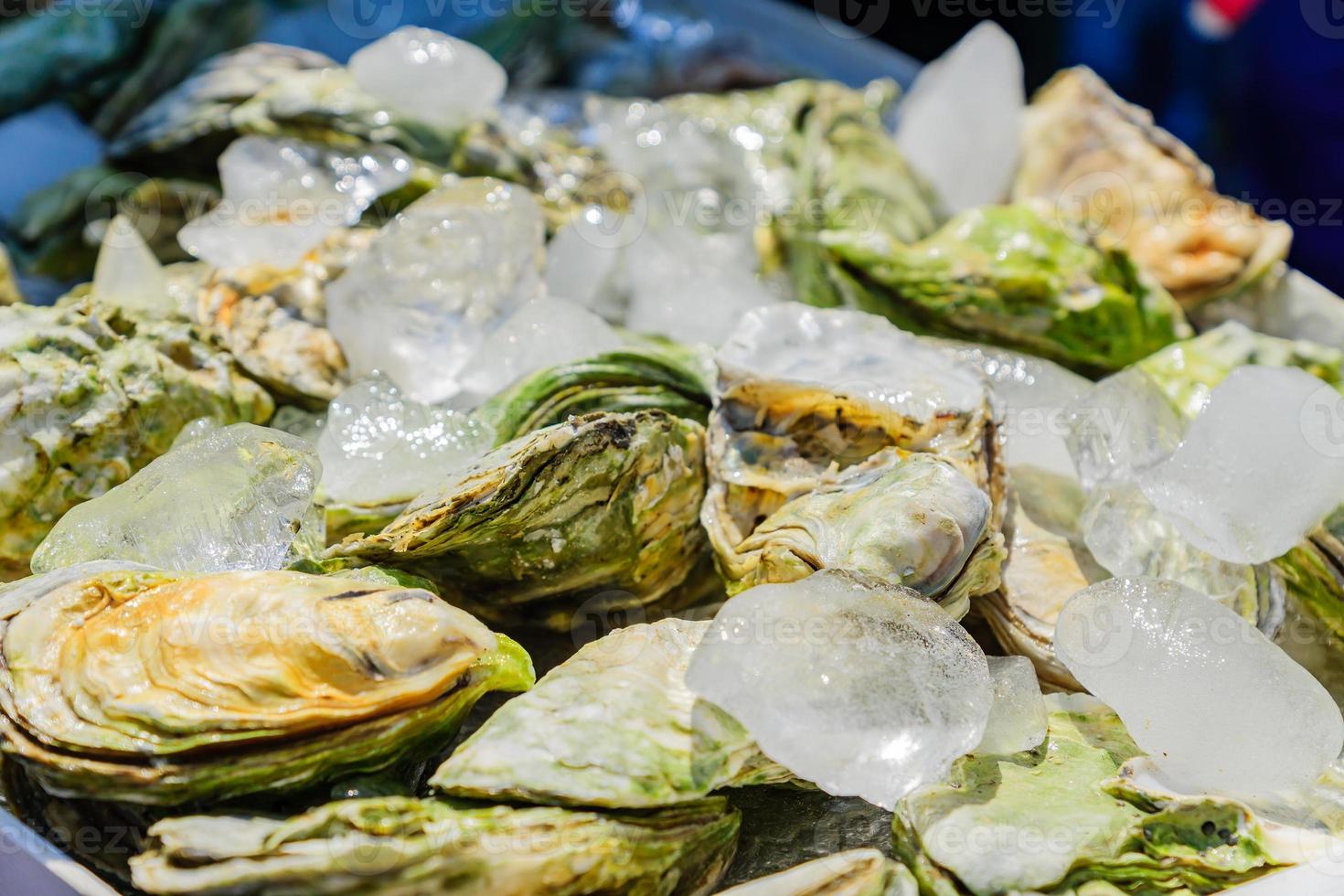 beaucoup d'huîtres fraîches fermées sur glace. fermer. marché aux