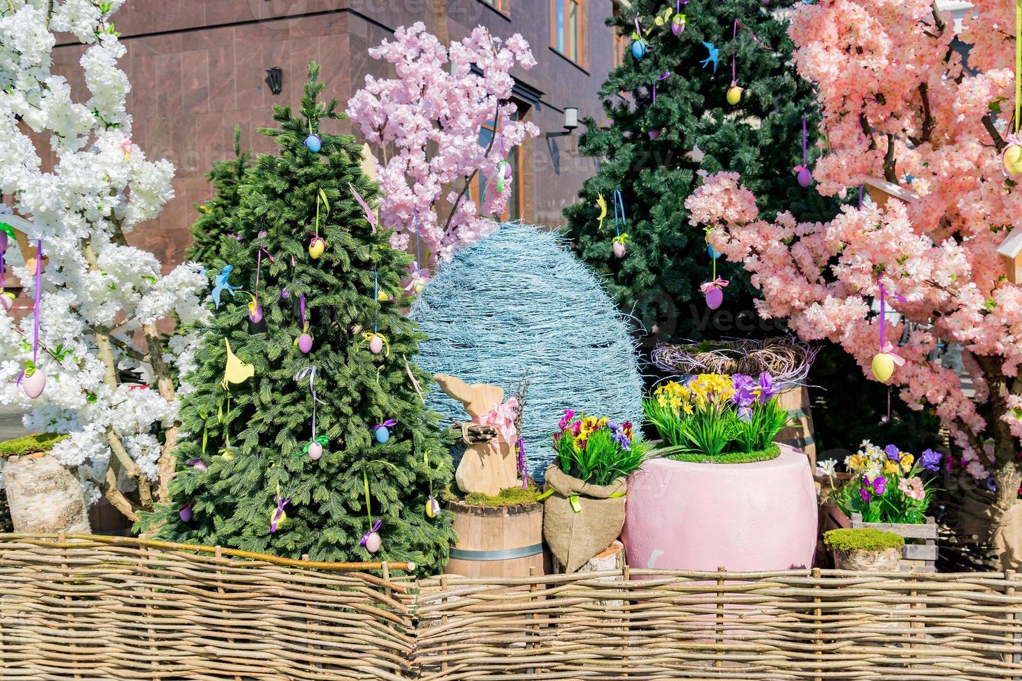 décorations de rue pour les vacances de Pâques - œufs, lapins, arbres en fleurs et clôture en osier photo