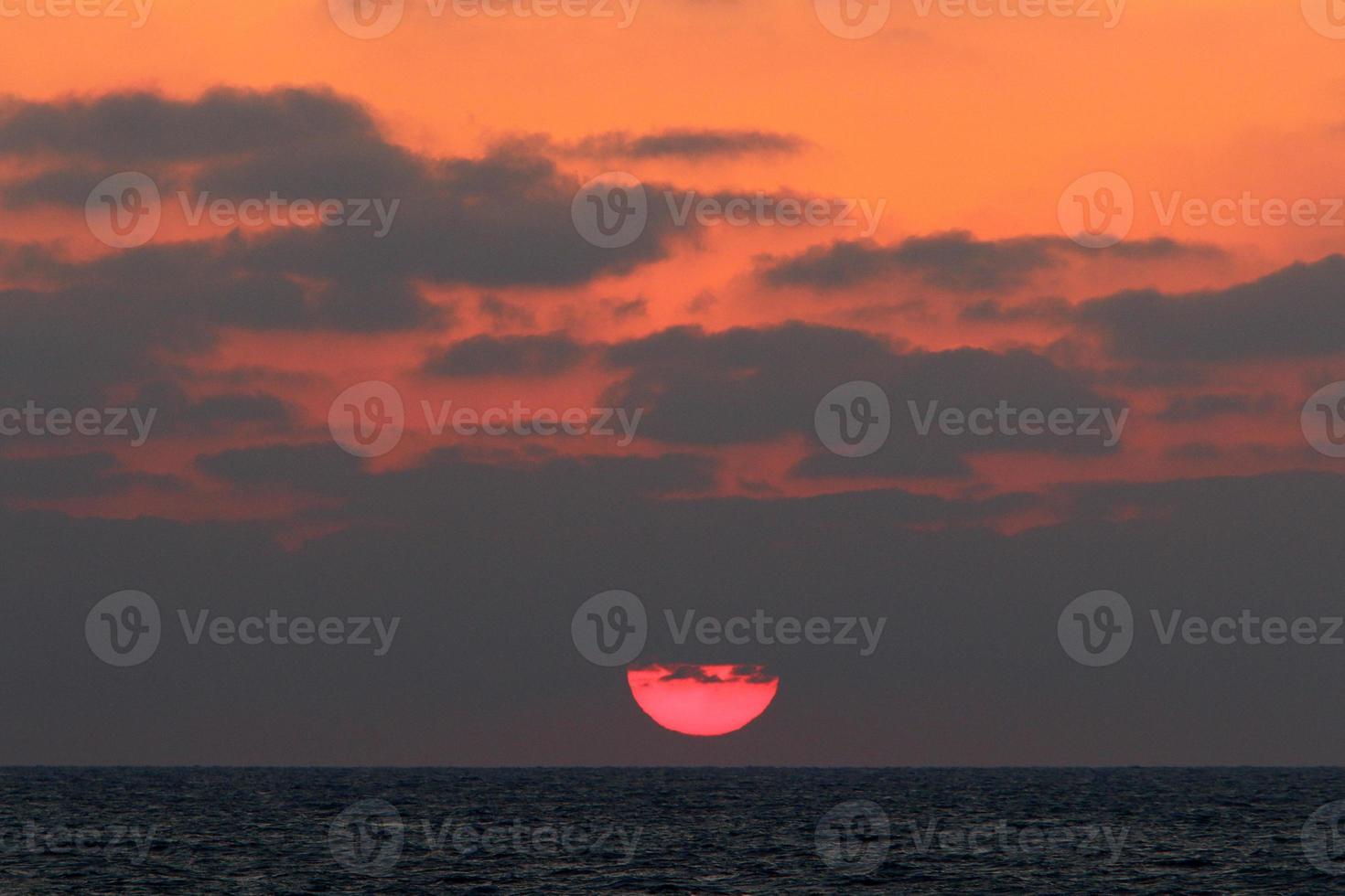 le soleil se couche sous l'horizon sur la mer méditerranée dans le nord d'israël. photo