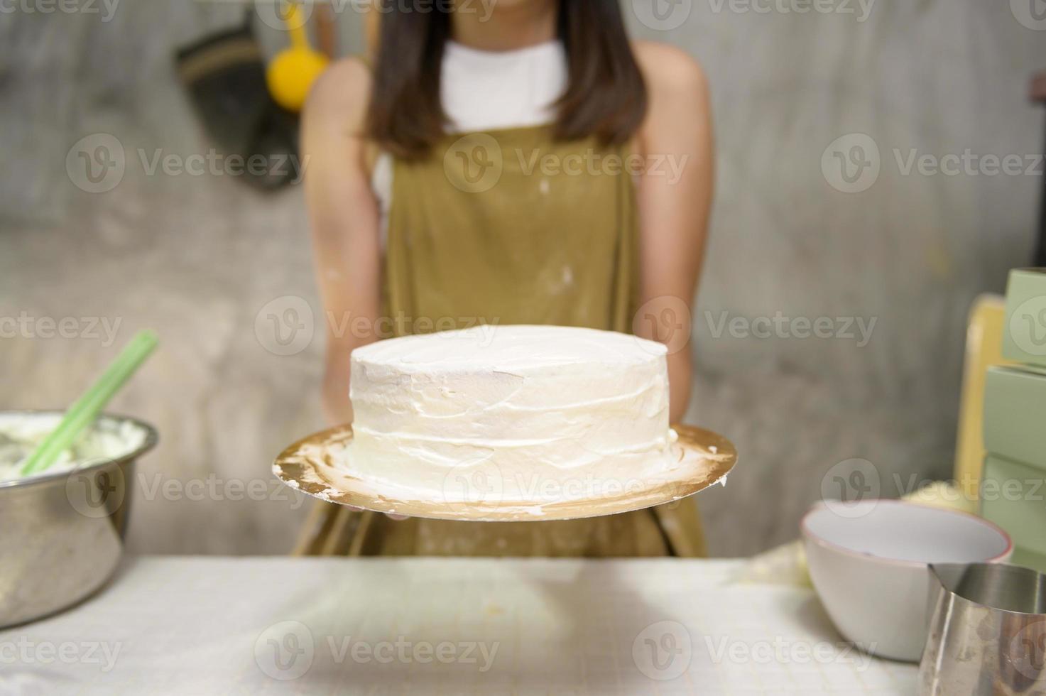 gros plan sur une belle jeune femme cuit dans sa cuisine, sa boulangerie et son café photo