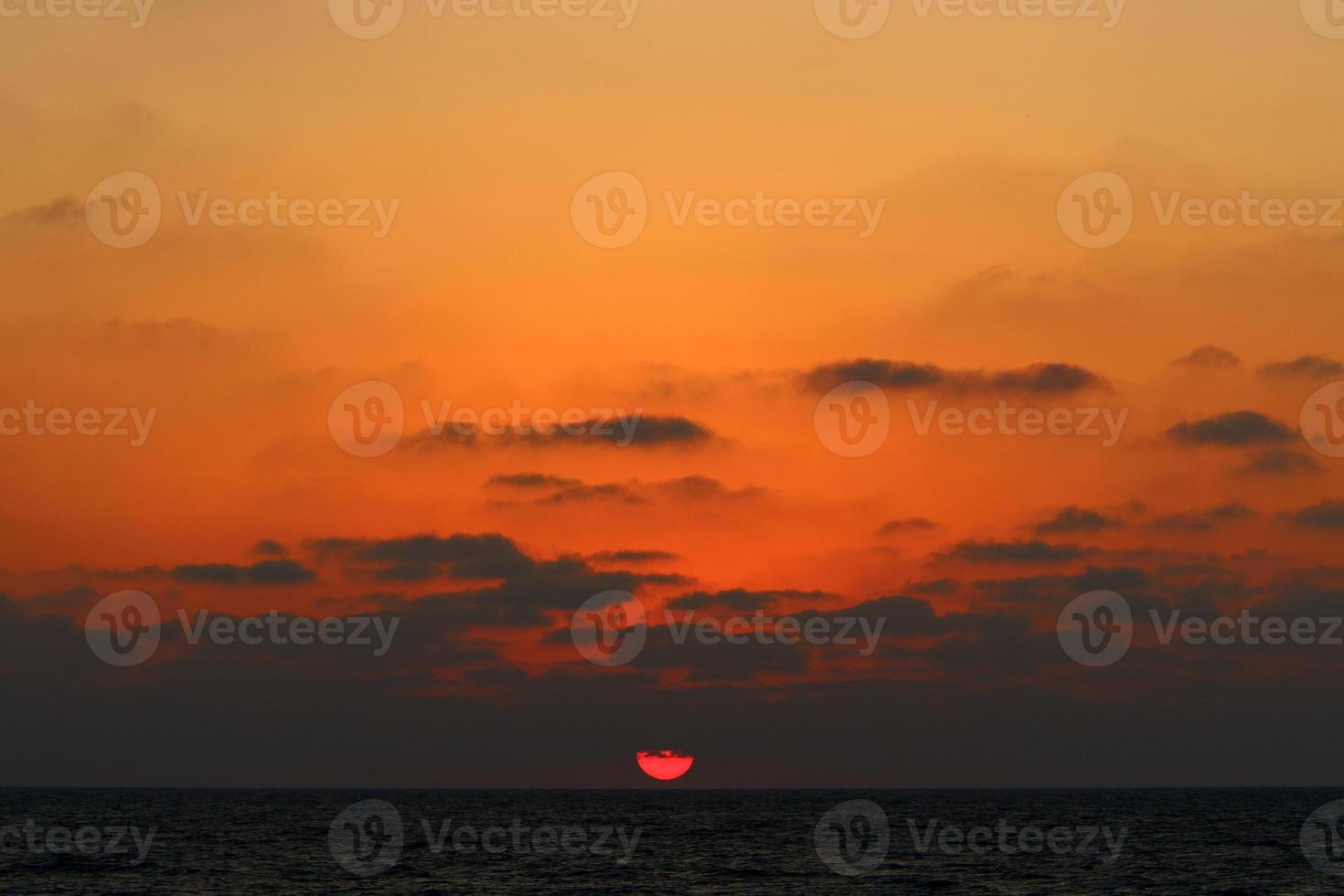 le soleil se couche sous l'horizon sur la mer méditerranée dans le nord d'israël. photo