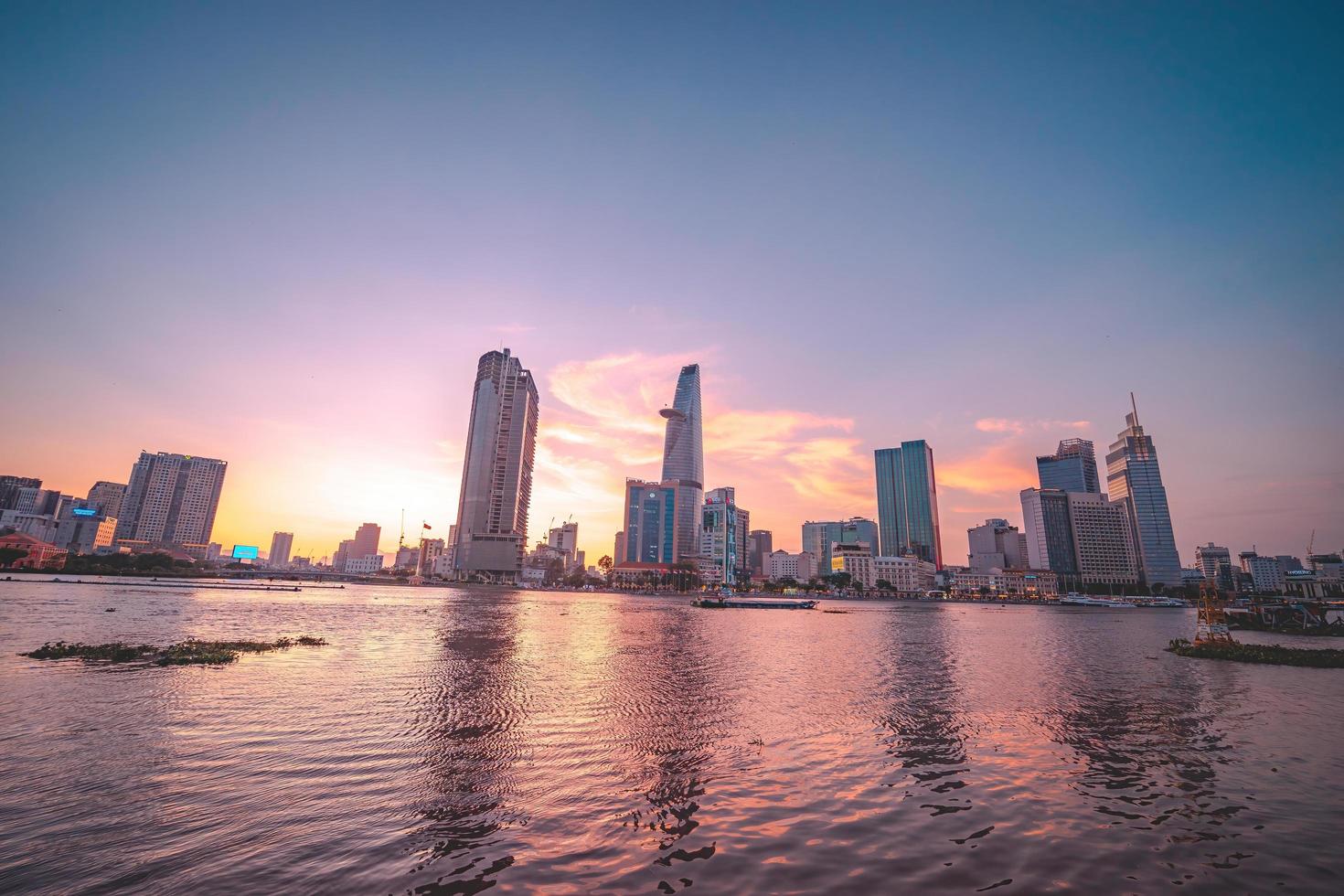 ho chi minh, vietnam - 13 février 2022 vue sur le bâtiment de la tour financière bitexco, les bâtiments, les routes, le pont thu thiem et la rivière saigon à ho chi minh ville au coucher du soleil. image panoramique de haute qualité. photo