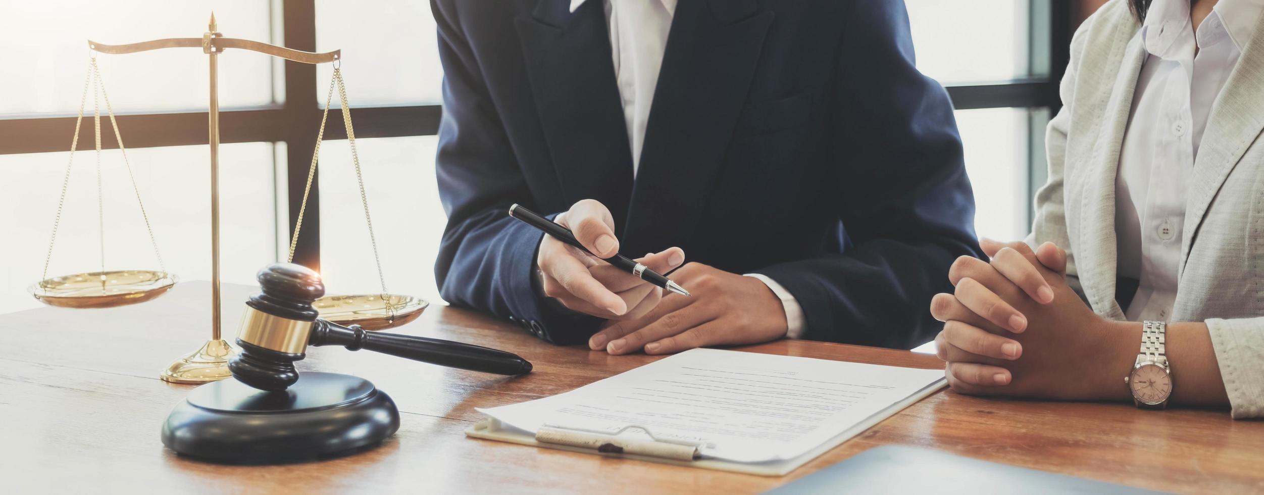 client client signant un contrat et discutant d'affaires avec des consultants juridiques, un notaire ou un avocat de la justice avec un ordinateur portable et un marteau de juge en bois sur le bureau du bureau de la salle d'audience, concept de service juridique photo