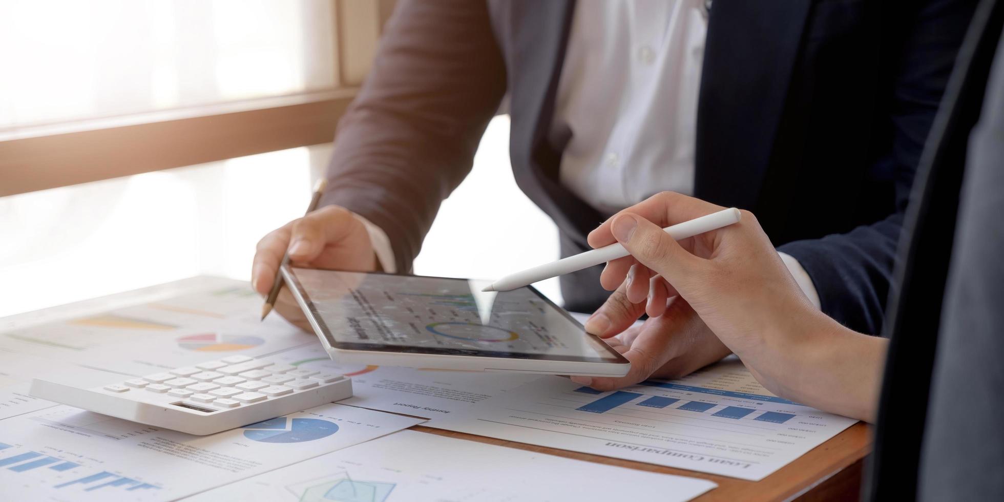 consultation de l'équipe des gestionnaires de fonds et discussion sur l'analyse du marché boursier d'investissement par tablette numérique. photo