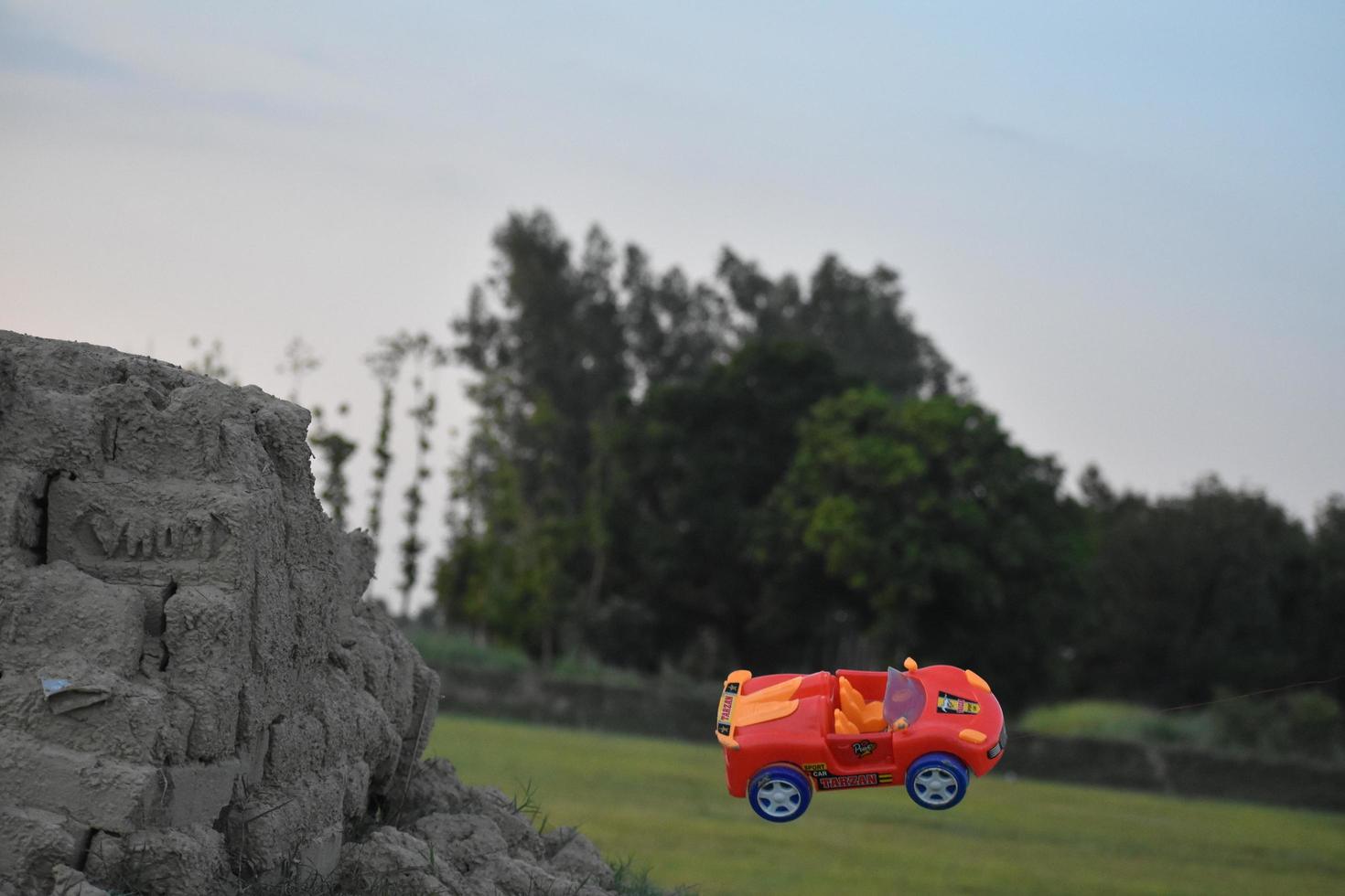 les jouets de la voiture rouge tombent de la colline photo