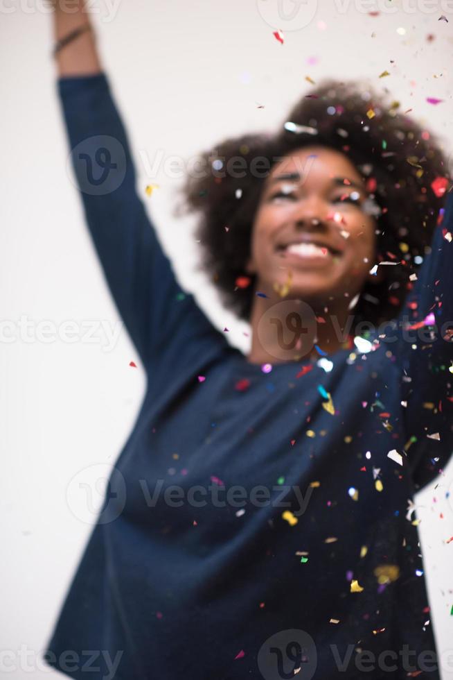 femme afro-américaine soufflant des confettis dans l'air photo