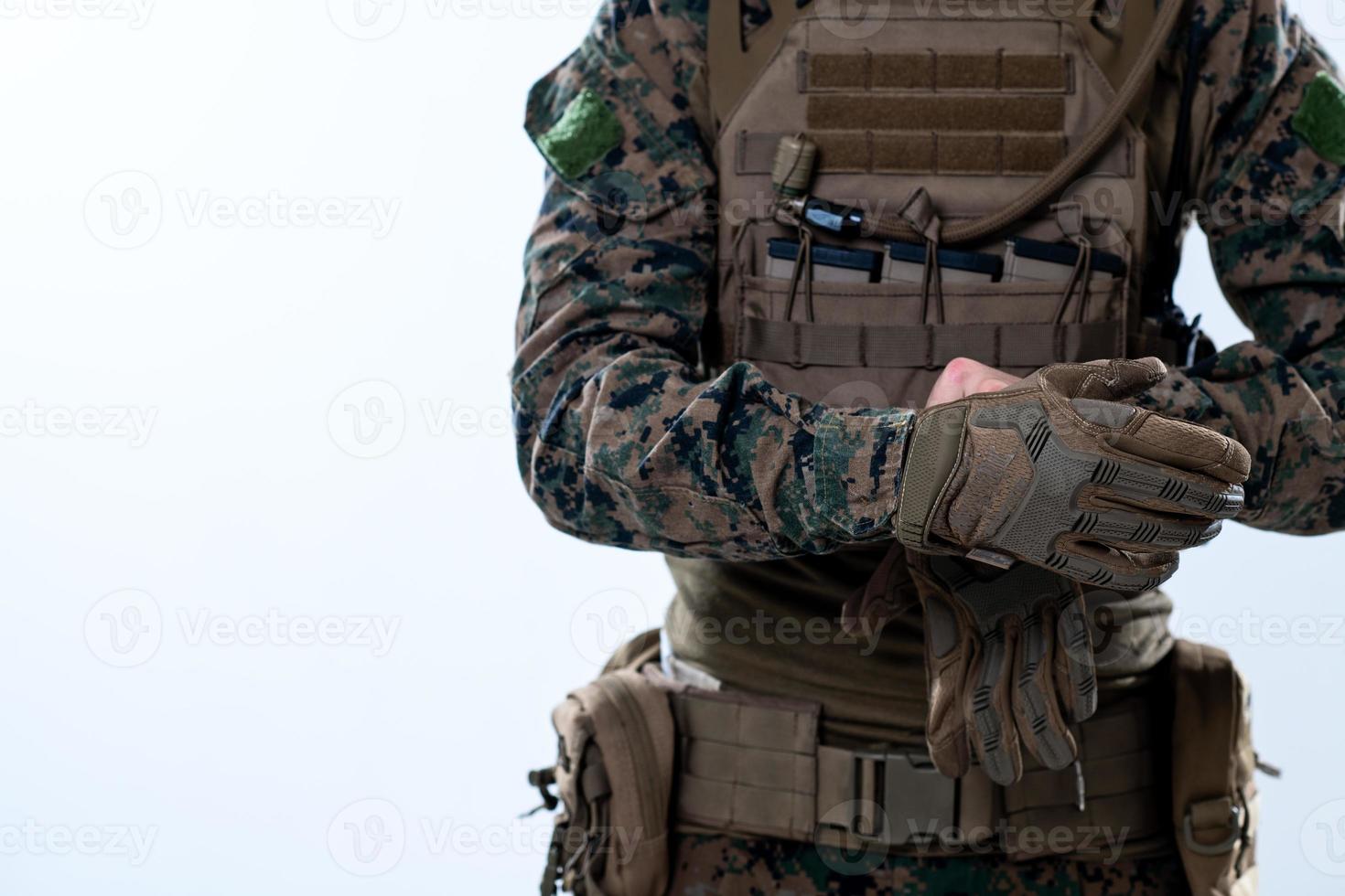 gros plan sur les mains d'un soldat mettant des gants de combat protecteurs photo