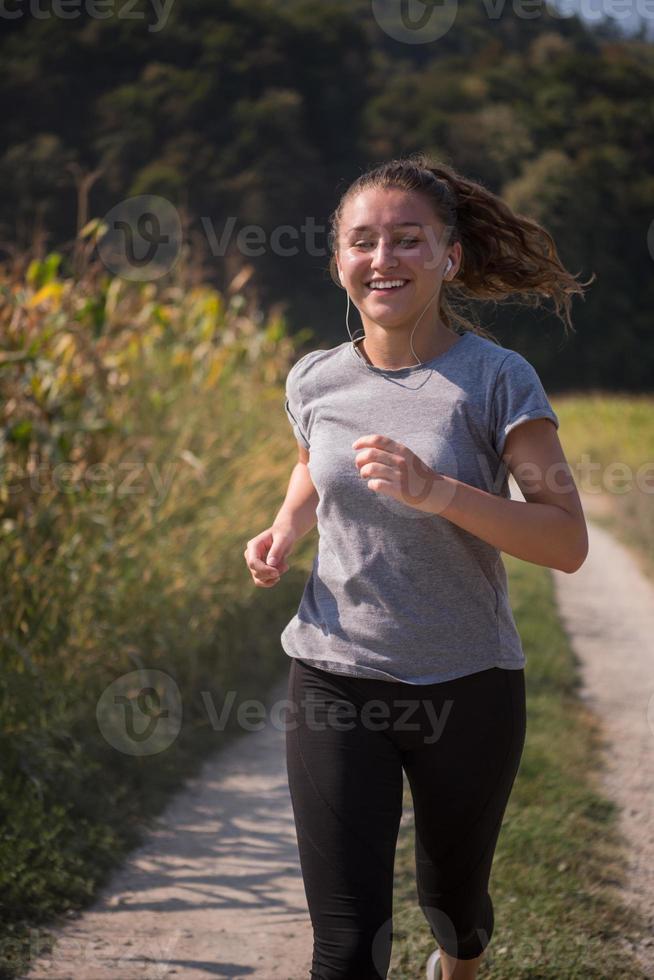 femme faisant du jogging le long d'une route de campagne photo