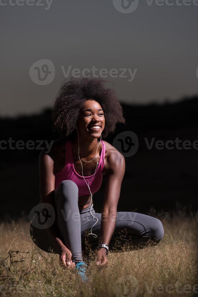 Black woman runner resserrant les lacets photo