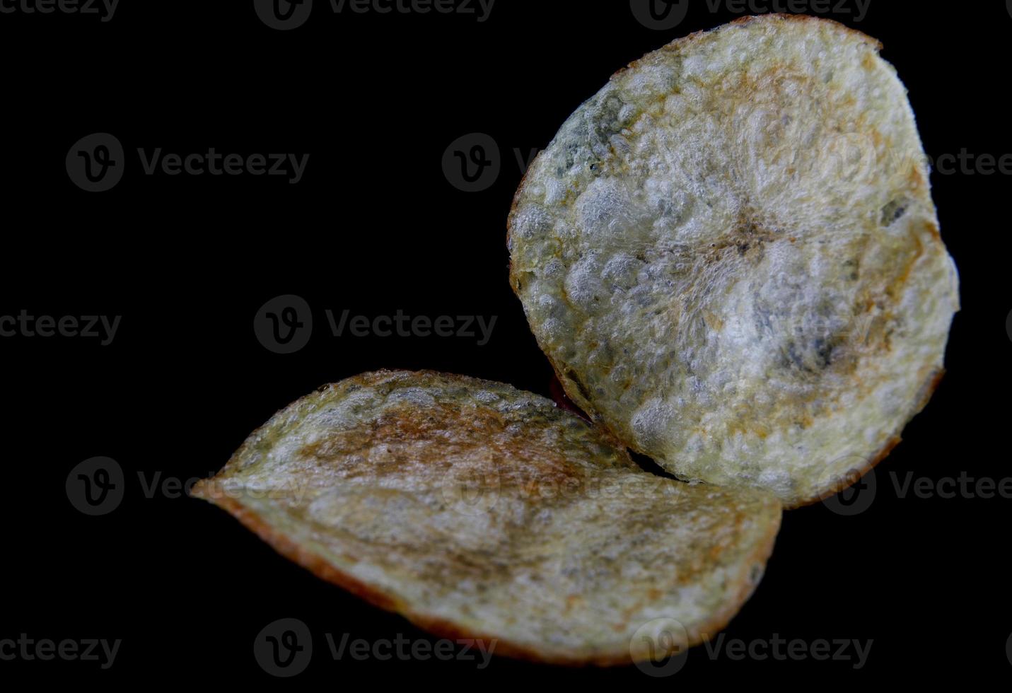 les croustilles croustillantes sont isolées sur fond noir. photo