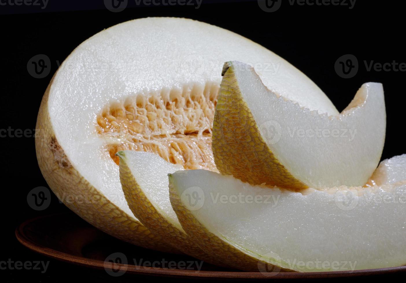 tranches de melon mûr et demi-melon sur une plaque d'argile. une vue de côté. photo