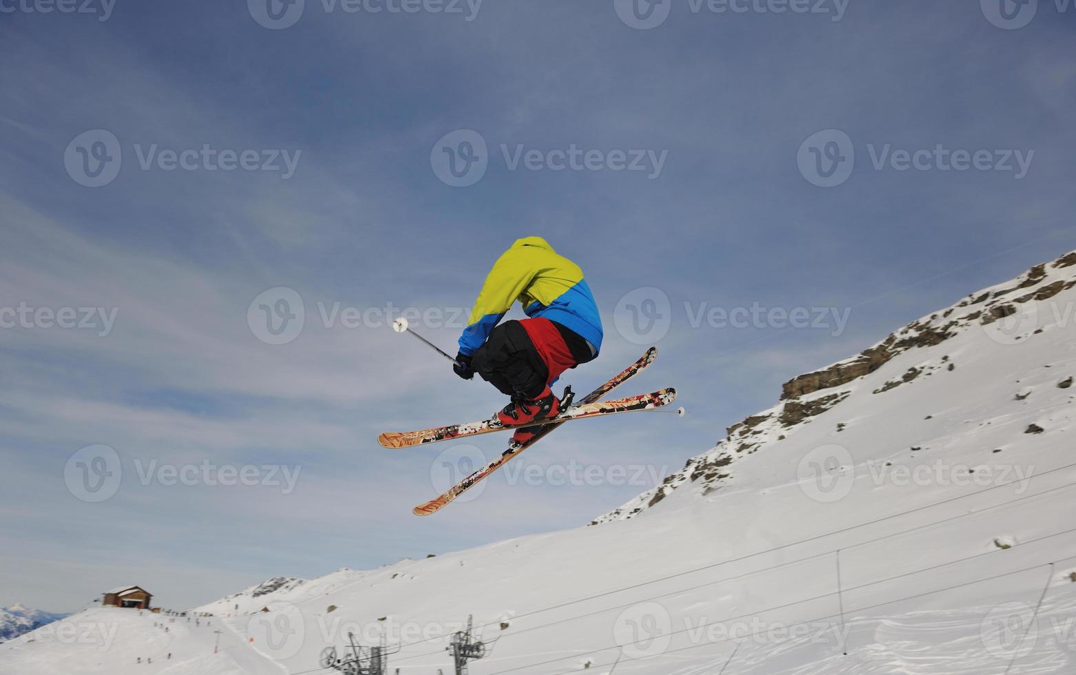 heureux jeune homme s'amuser en hiver au sommet de la montagne photo