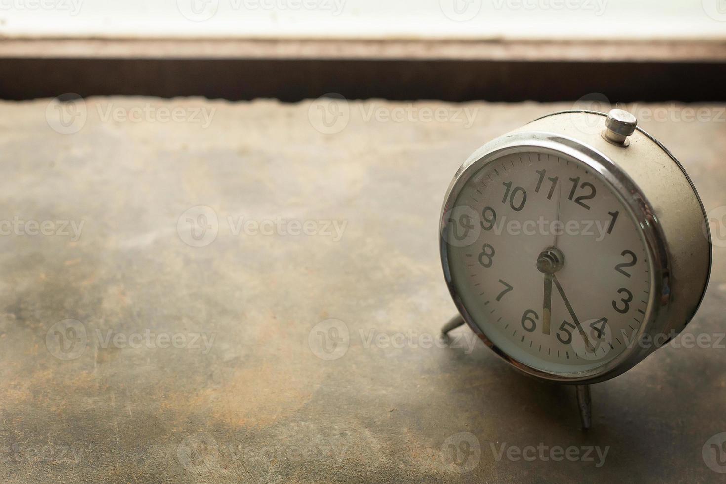 alarme d'horloge vintage blanche près de la lumière de la fenêtre. photo