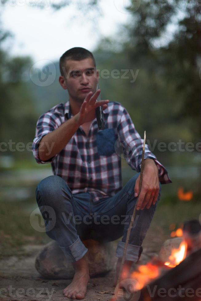 jeunes amis se détendant autour d'un feu de camp photo