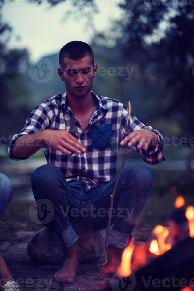 jeunes amis se détendant autour d'un feu de camp photo