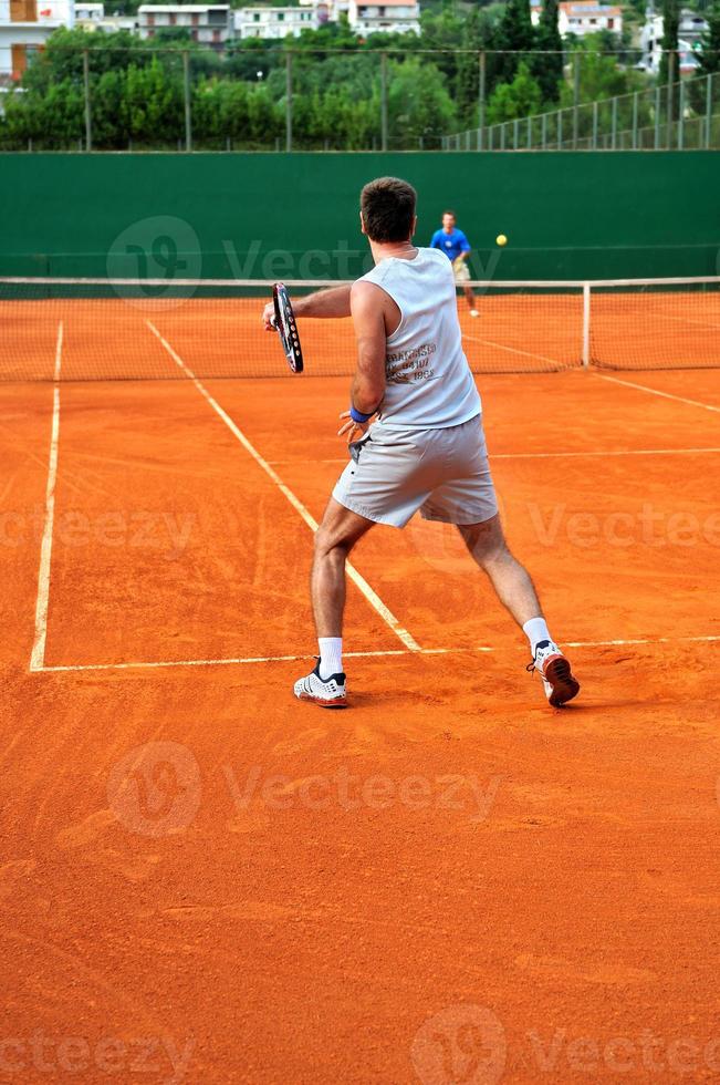 l'homme joue au tennis à l'extérieur photo