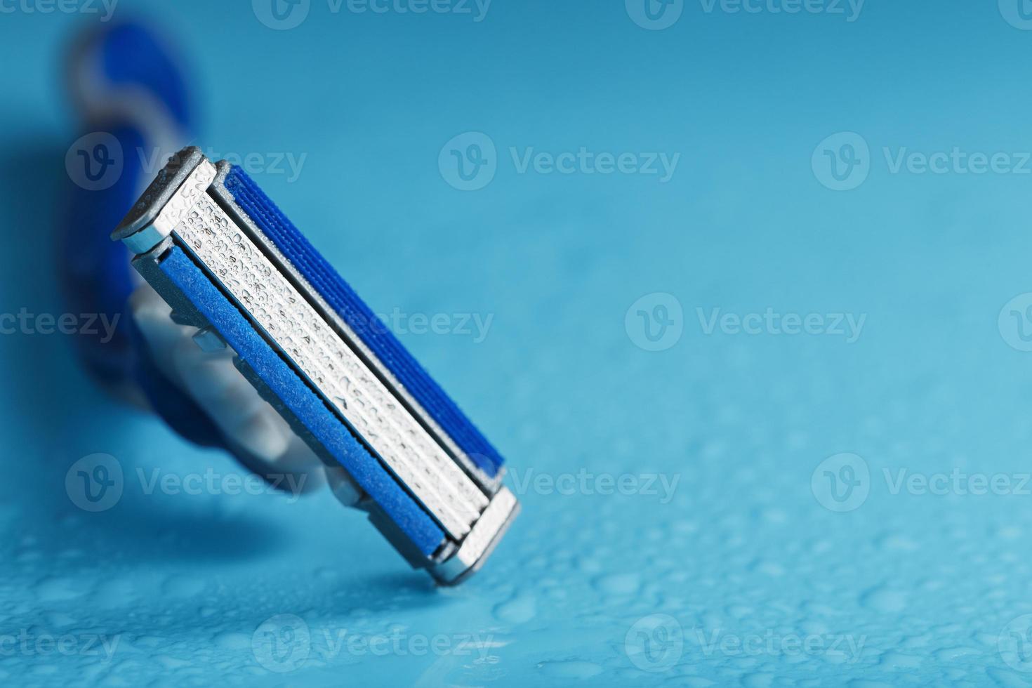 des lames de rasoir sur fond bleu avec des gouttes d'eau glacée photo
