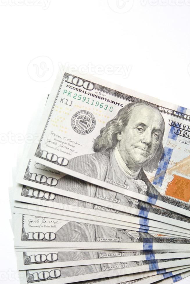 Billets de 100 dollars américains placés sur un fond blanc. photo