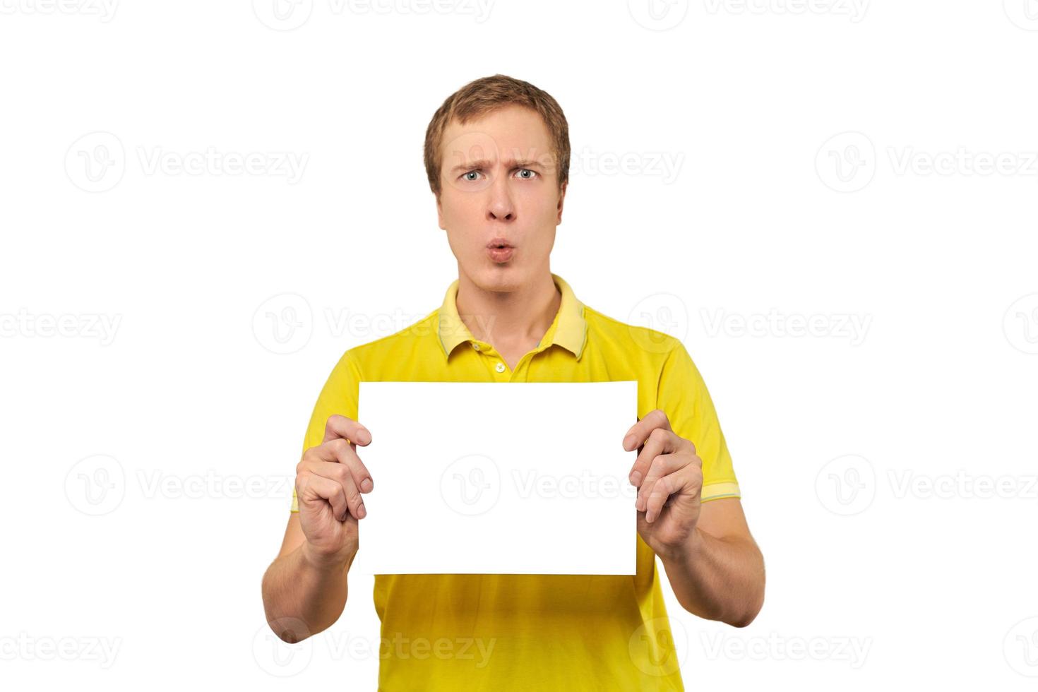 jeune homme surpris tenant une feuille de papier vierge, maquette de papier isolée sur fond blanc photo