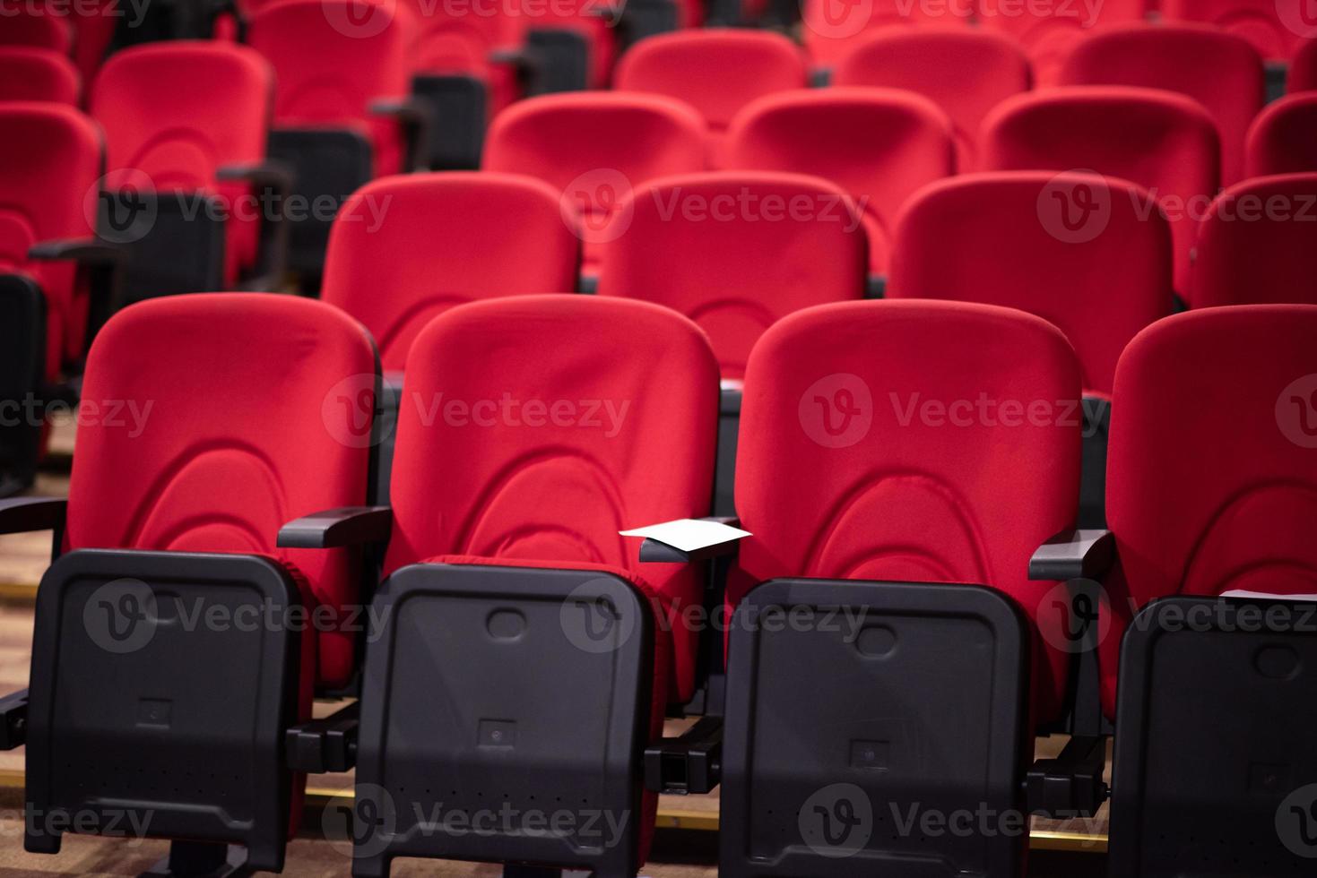 salle avec des rangées de sièges rouges photo