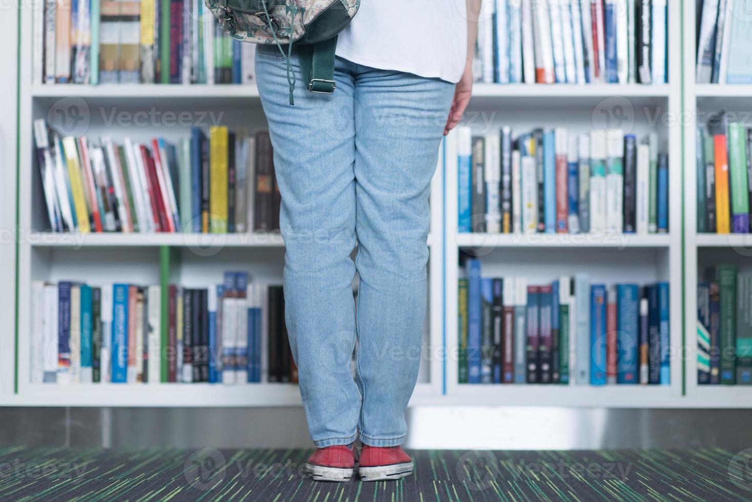 étudiante célèbre en sélectionnant un livre à lire dans la bibliothèque photo