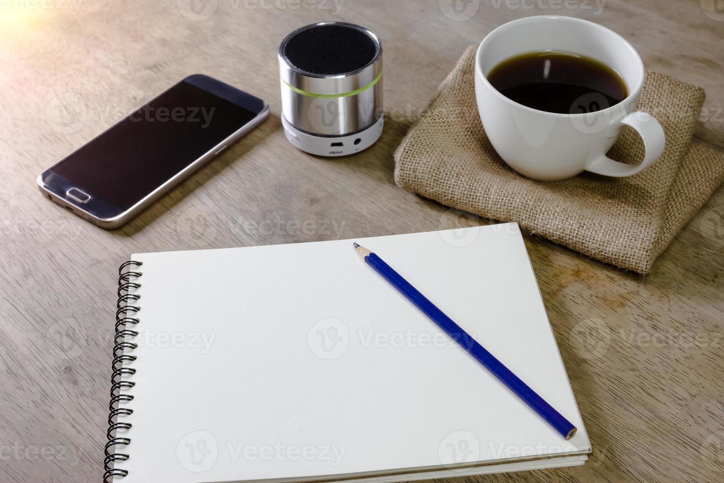carnet de notes avec haut-parleur crayon café et smartphone sur le bureau photo