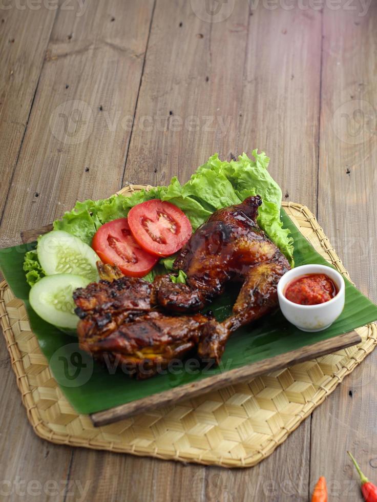 délicieux poulet cuit au four croustillant fraîchement cuit est appétissant servi sur un plat en bois photo