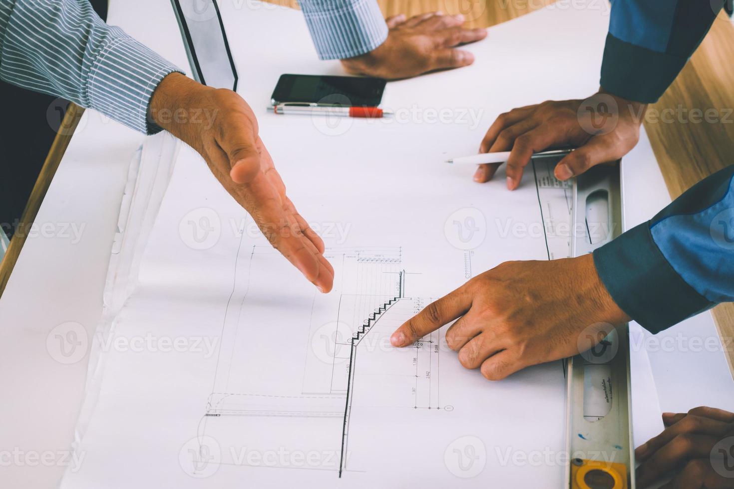 équipe d'ingénieurs discutant de l'esquisse du plan d'architecture sur le chantier de construction. photo