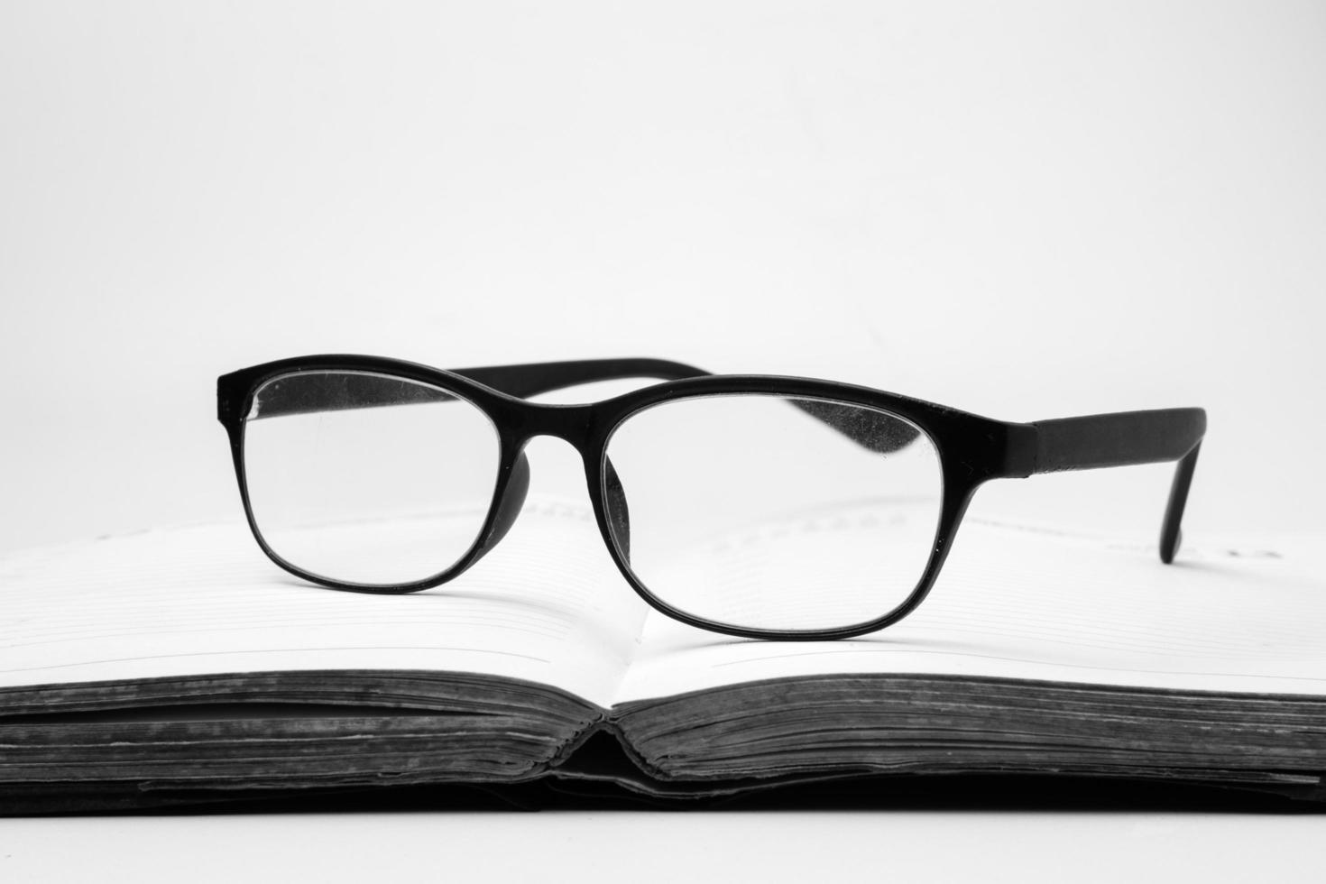 lunettes sur un livre ouvert, ton noir et blanc photo
