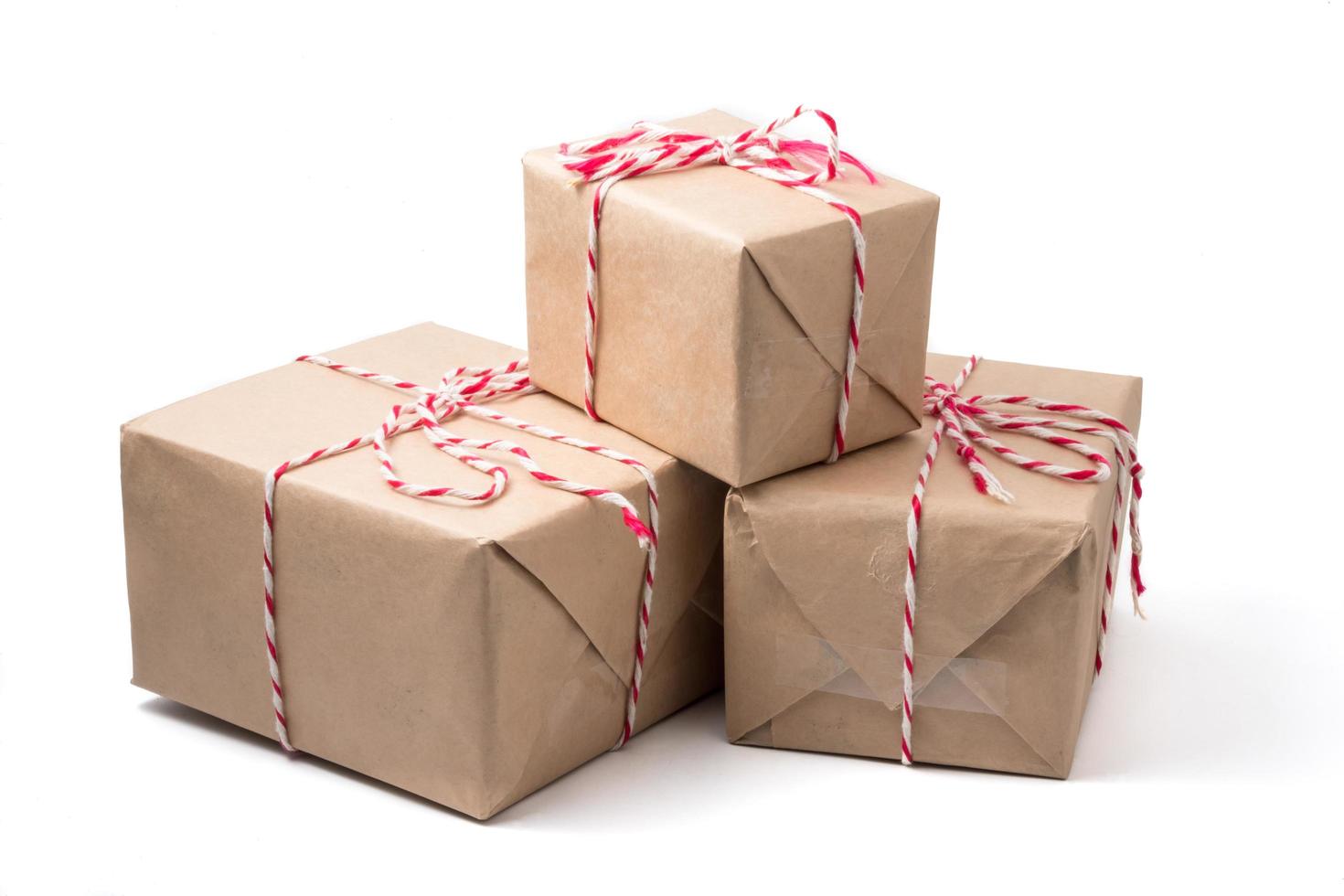 paquets cadeaux enveloppés dans du papier brun sur fond blanc. photo