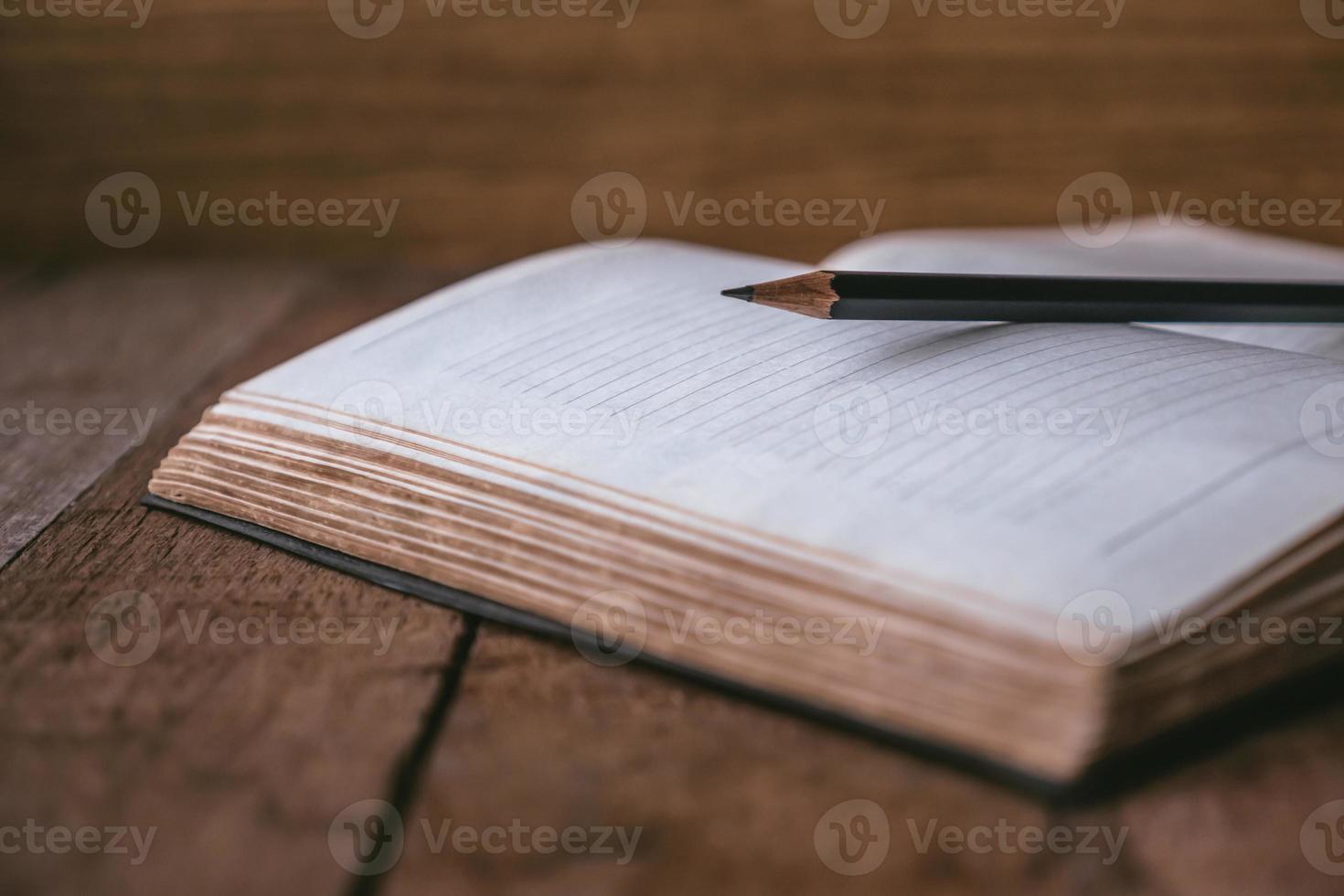 cahier vierge avec un crayon sur une table en bois. mise au point sélective photo