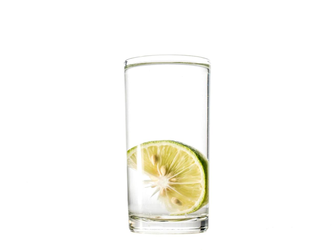verre d'eau au citron vert sur fond blanc. photo