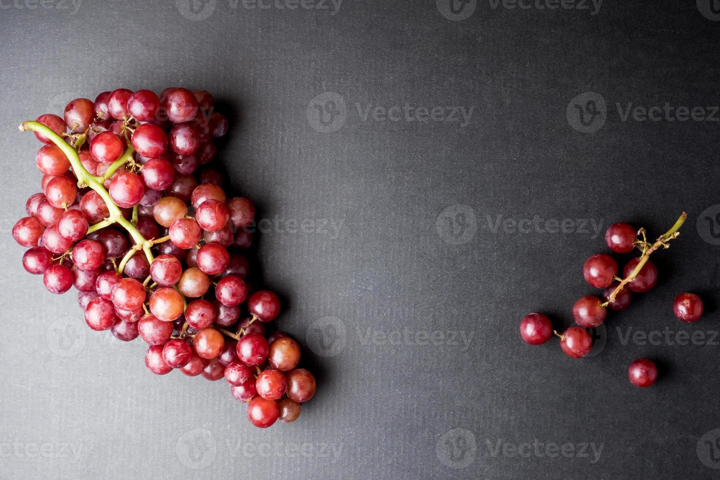 vue de dessus de raisins rouges sur fond noir. espace libre pour le texte photo