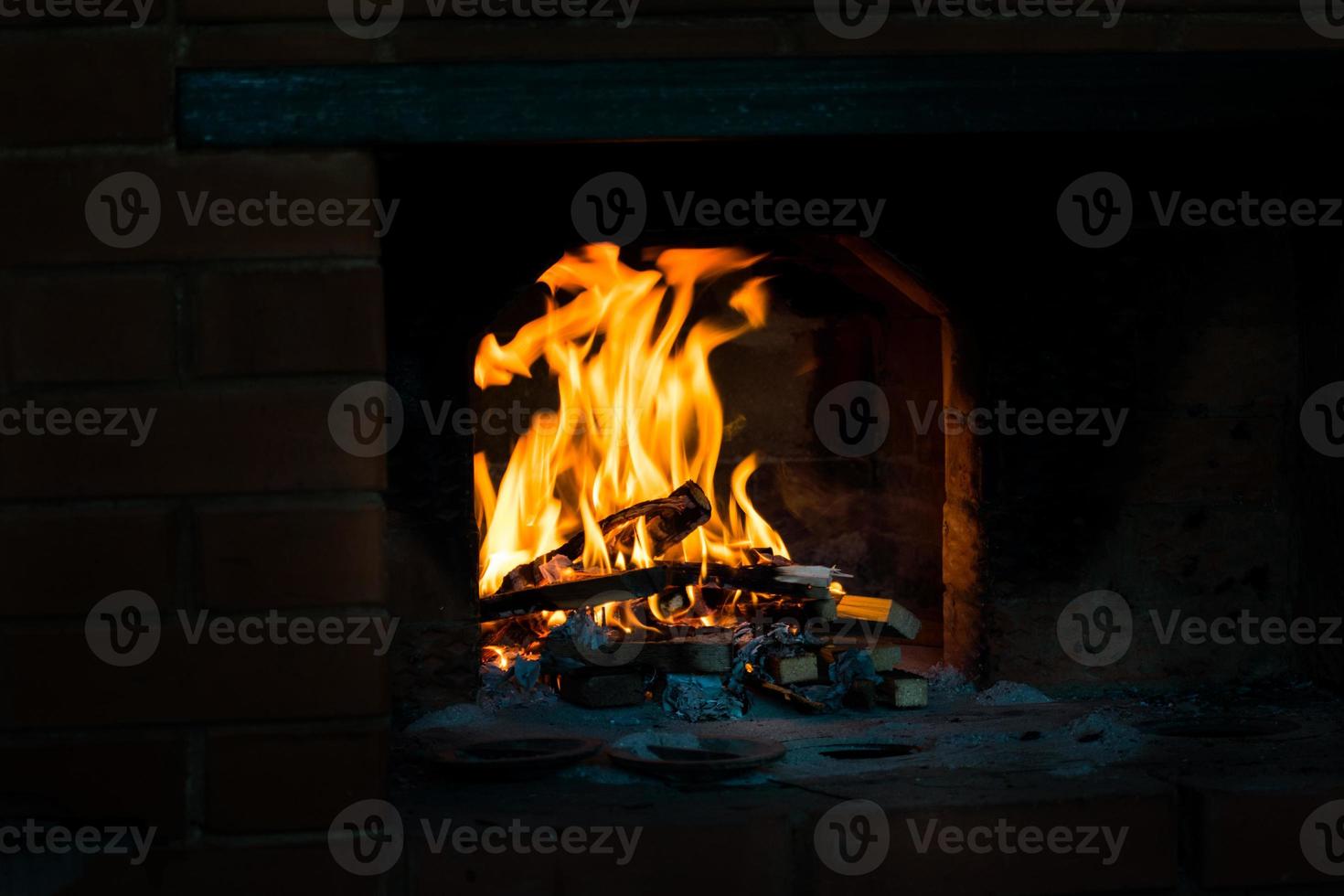 crête de flamme sur bois brûlant dans la cheminée. brûler du bois de chauffage dans un poêle russe. photo