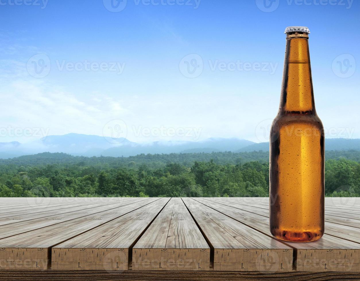 bouteille de bière avec des gouttes d'eau sur une terrasse de table en bois avec une atmosphère rafraîchissante le matin, paysage naturel photo