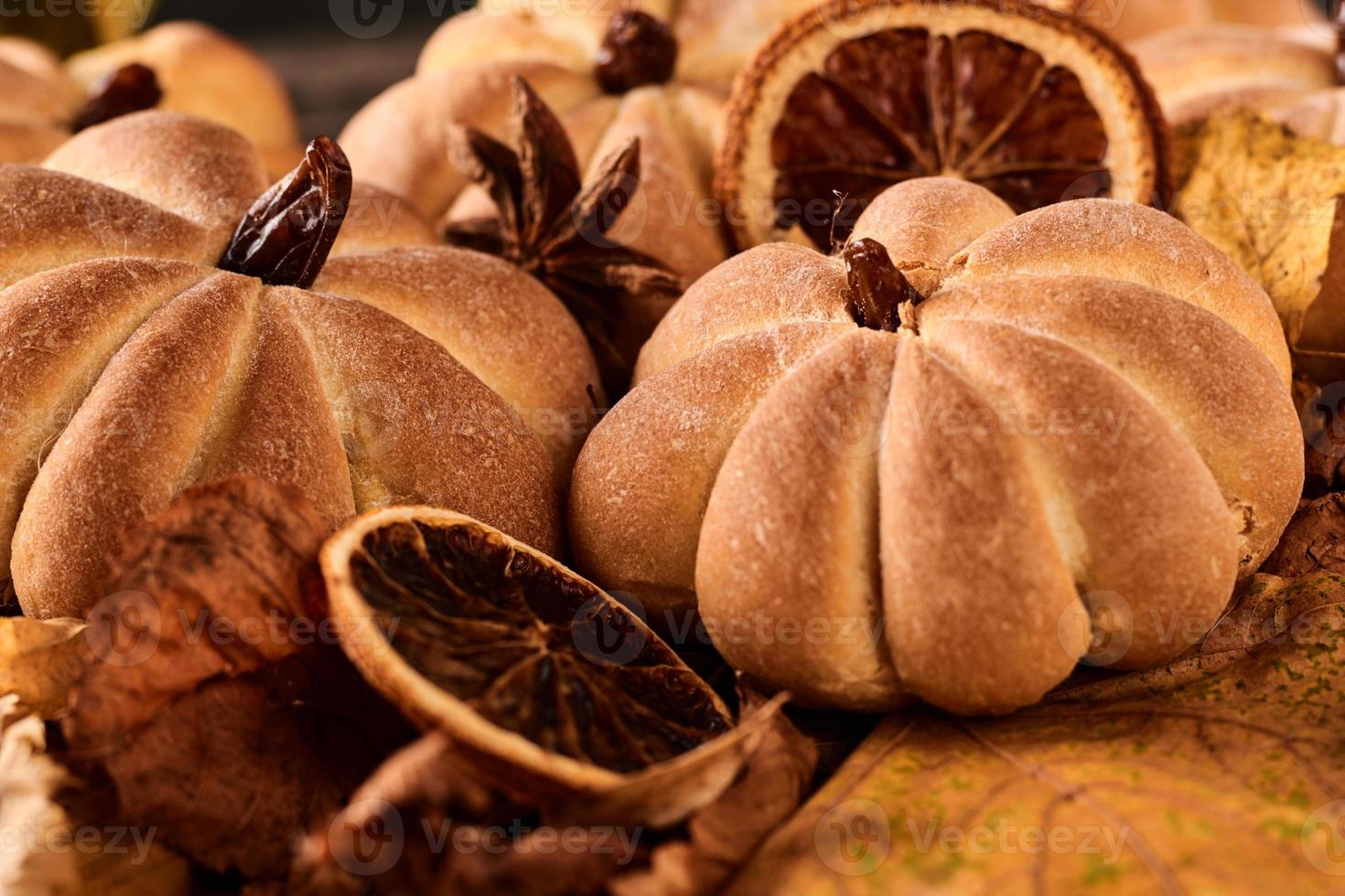 biscuits faits maison en forme de citrouille dans les feuilles d'automne. biscuits faits à la main d'halloween sur une table, gros plan photo