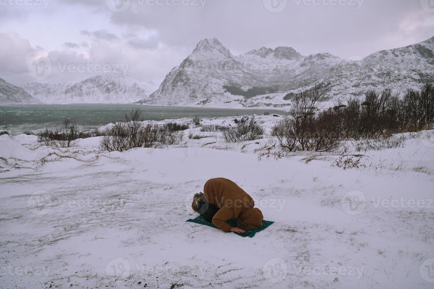 voyageur musulman priant dans une froide journée d'hiver enneigée photo