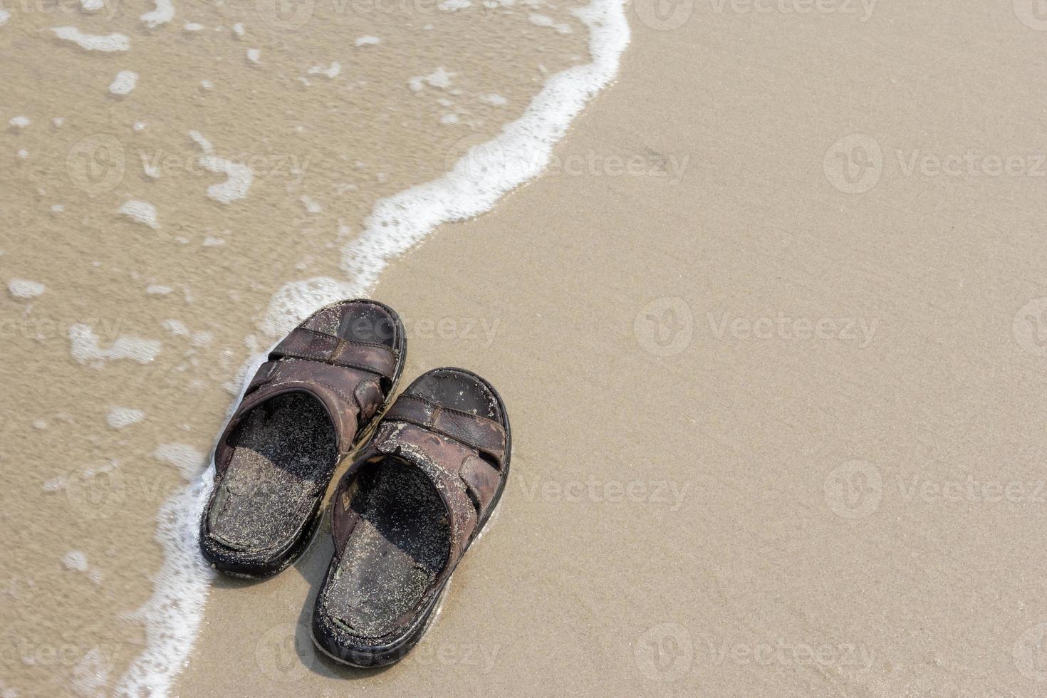 vieilles sandales sur la plage photo