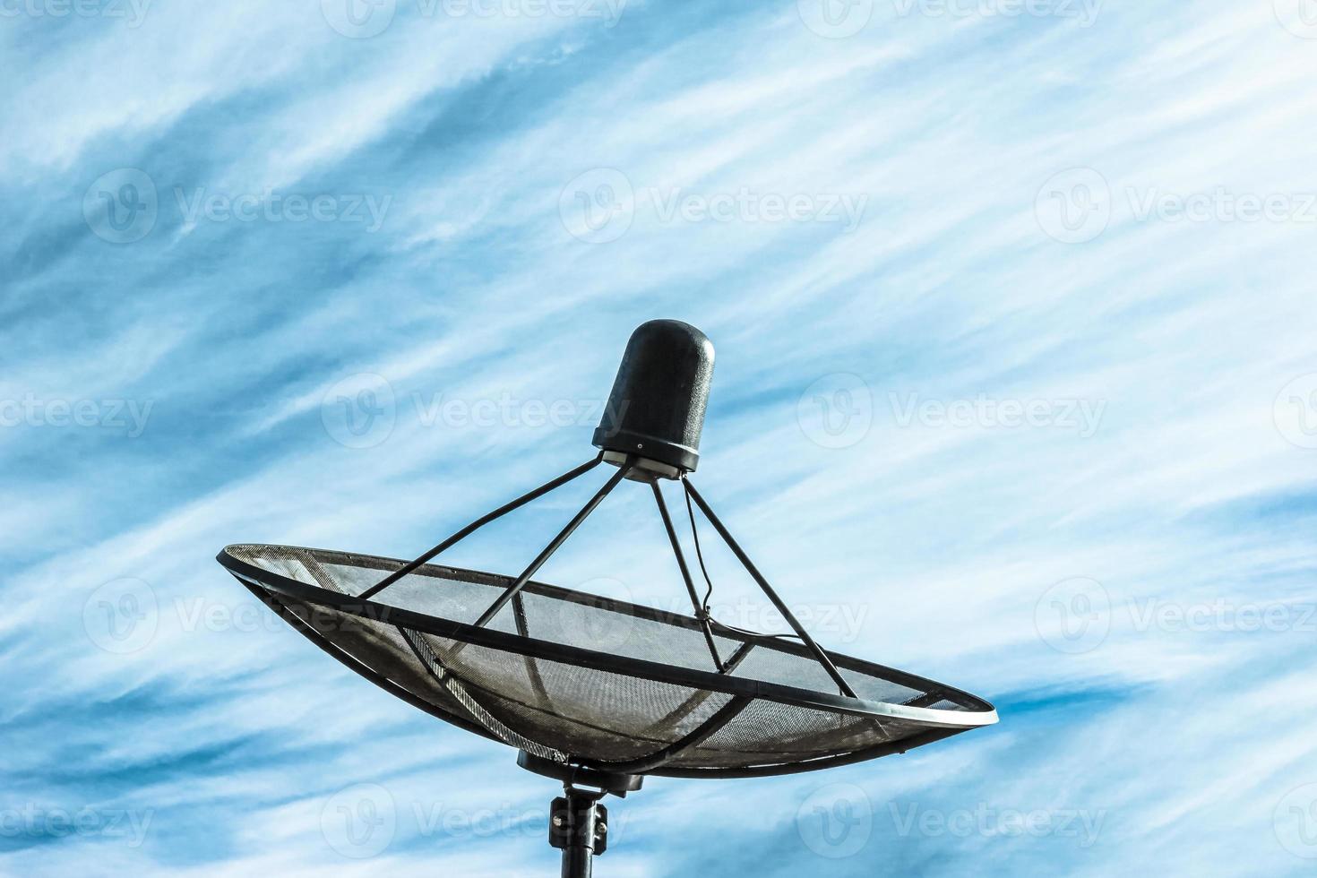 antenne parabolique noire dans le ciel bleu, effet de filtre. photo