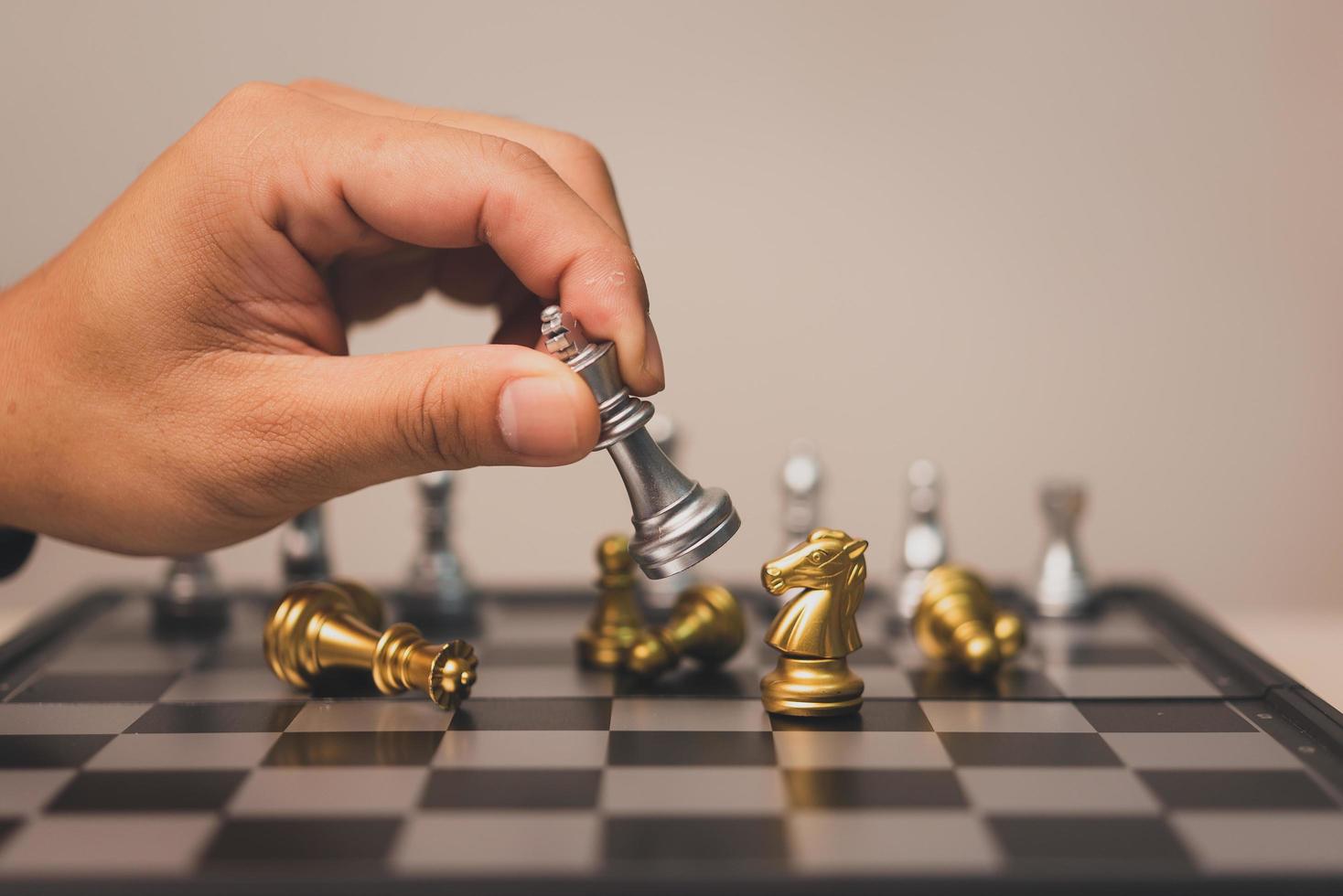 homme de main tenant le stand de jeu d'échecs sur l'échiquier. concept d'investissement de succès de travail d'équipe de stratégie d'entreprise. photo