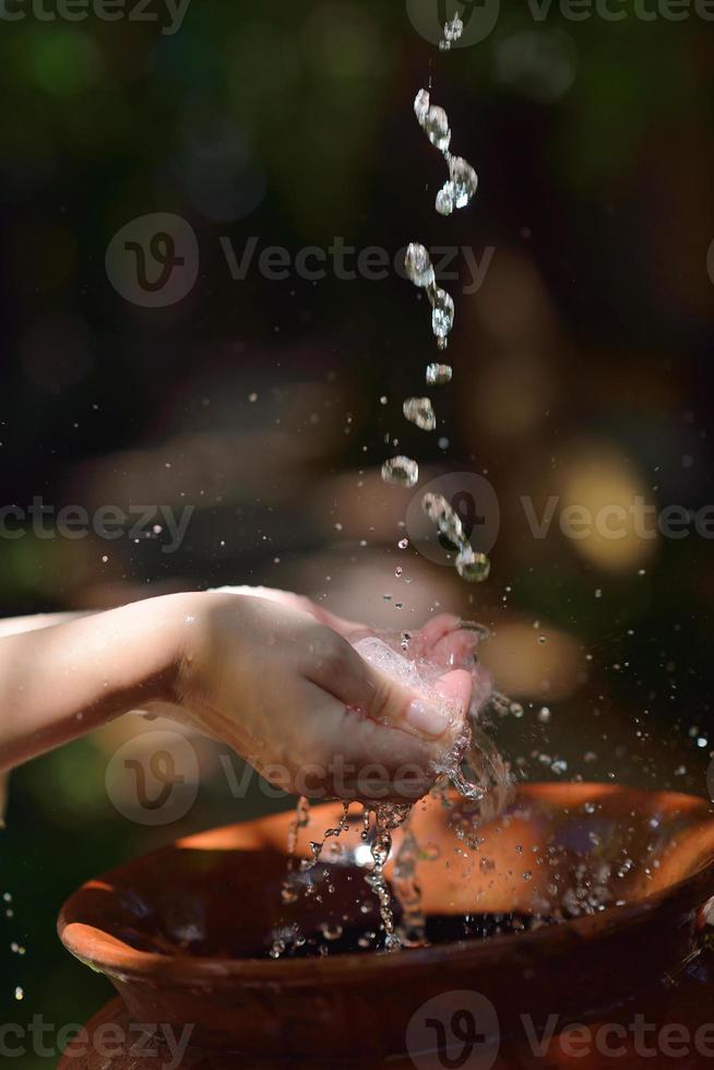 éclabousser de l'eau douce sur les mains de la femme photo