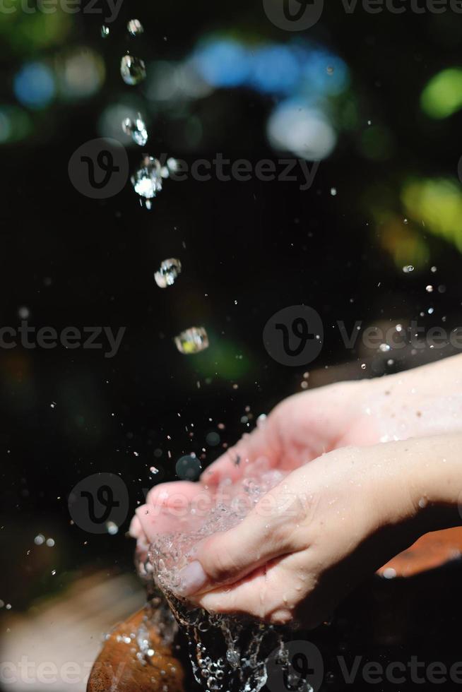 éclabousser de l'eau douce sur les mains de la femme photo