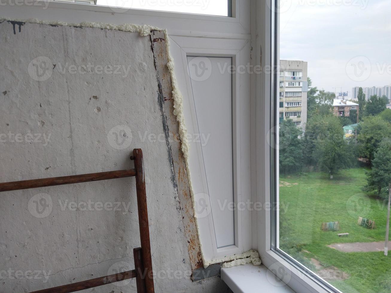 installé des fenêtres en métal-plastique sur le balcon d'un immeuble résidentiel photo