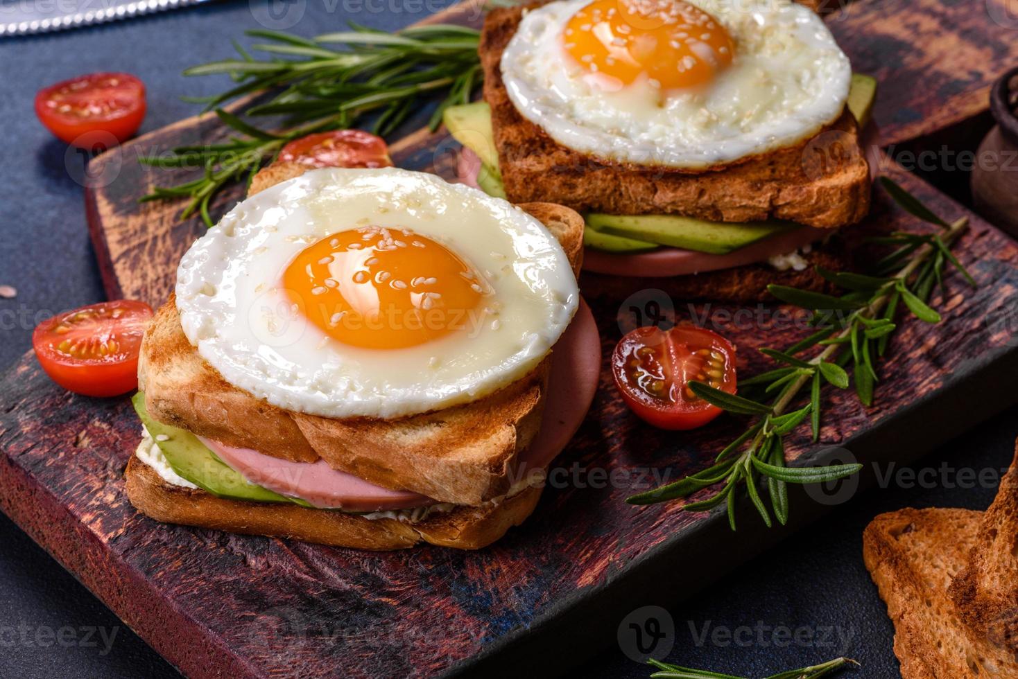 sandwichs frais et délicieux avec œuf au plat, jambon, beurre, avocat et graines de sésame photo